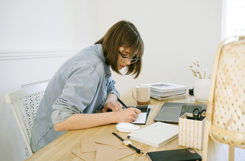 Woman sitting at a desk and writing in a notebook